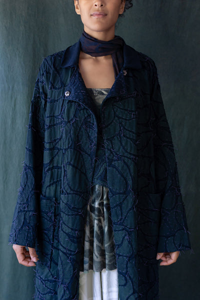The Bosque Coat with hand-sewn leaf design on model with Falcon Scarf.