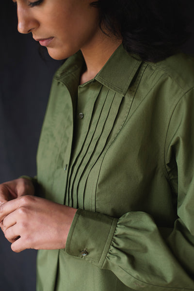 Close-up of model wearing The Tunica Operis shirt in Green.
