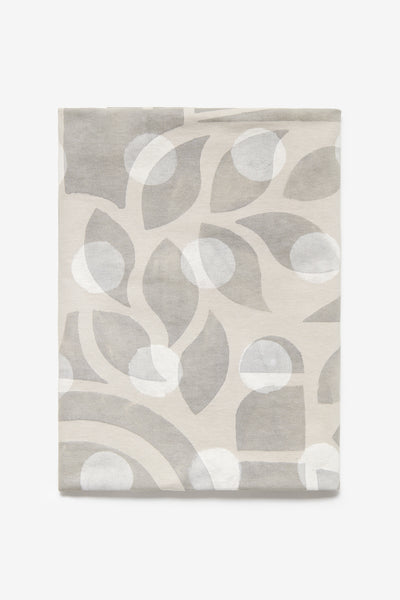 A yard of medium-weight jersey fabric with hand-painted abstract and large polka dot designs, predominantly in gray and white colors.