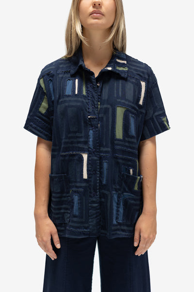 Close-up front view of model wearing the Sonia Oversized Shirt in Navy with Peacock, Verdant, and Wax backing layers, along with the Crop Pant in Navy. 