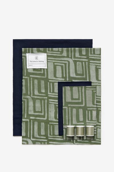 Contents of the Slim Scarf DIY kit showing Sonia painted fabric in Verdant, solid color fabric in Navy, and thread in sage.