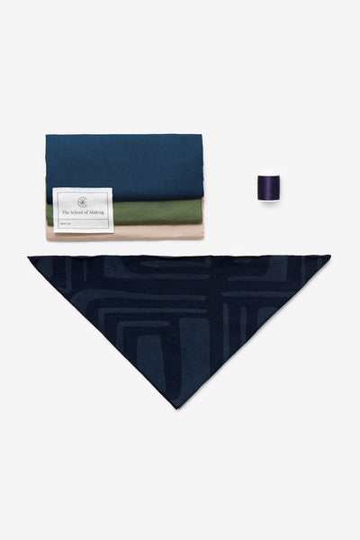 Contents of the Triangle Bandana Kit, shown with Navy Sonia Bandana and scrap fabric in Peacock, Verdant, and Wax.